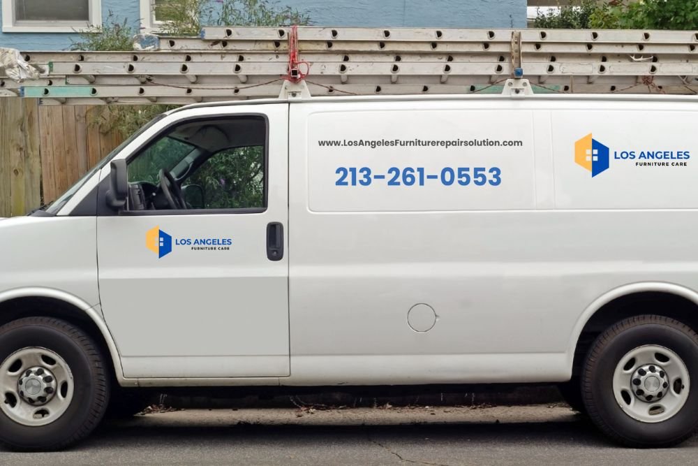 A white van branded with "Los Angeles" parked in front of a house, showing a phone number and website on its side.