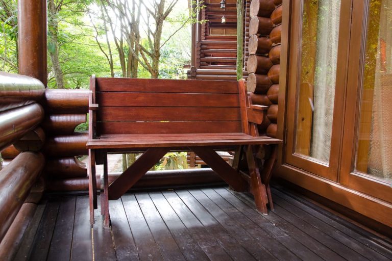A wooden bench placed on a wooden deck, showcasing the craftsmanship of furniture repair services.